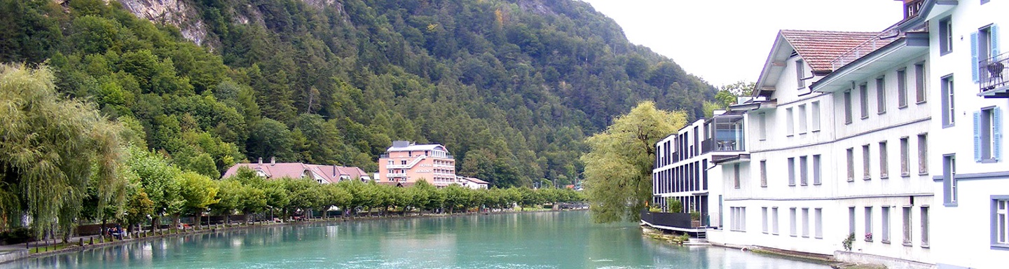 Die türkisgrüne Aare vor einer Häuserfront in Interlaken
