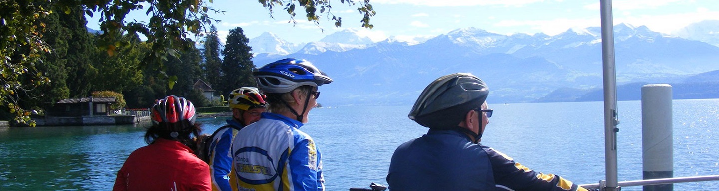 Radler genießen die Aussicht auf den Thunersee und die ihn umgebenden Berge.