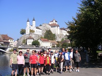 Reisegruppe vor der doppeltürmigen weißen Kirche von Aarburg